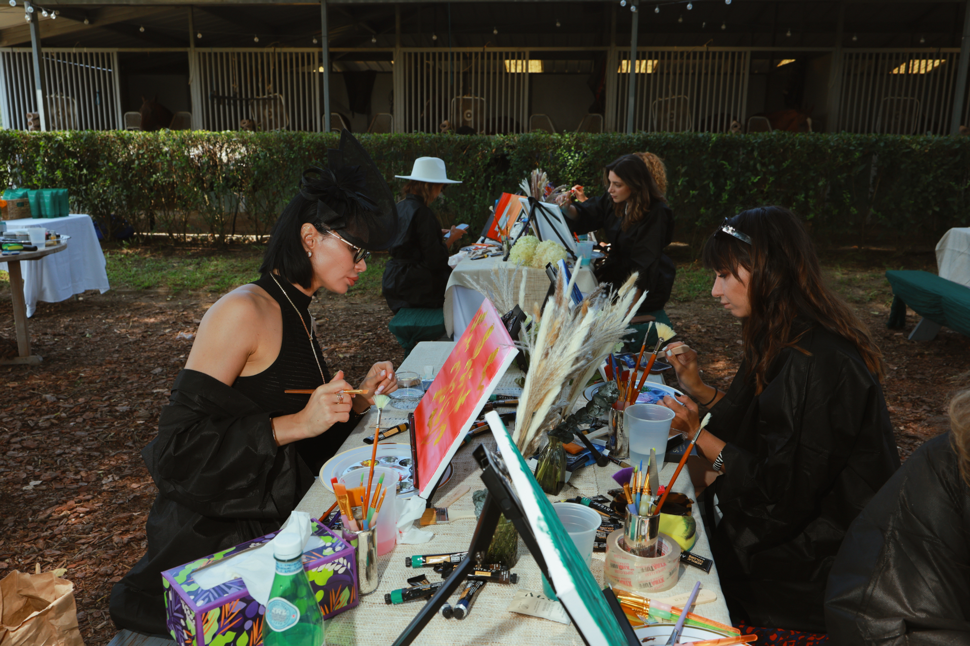 Guests painting together at a long table during an ELARTĒ event